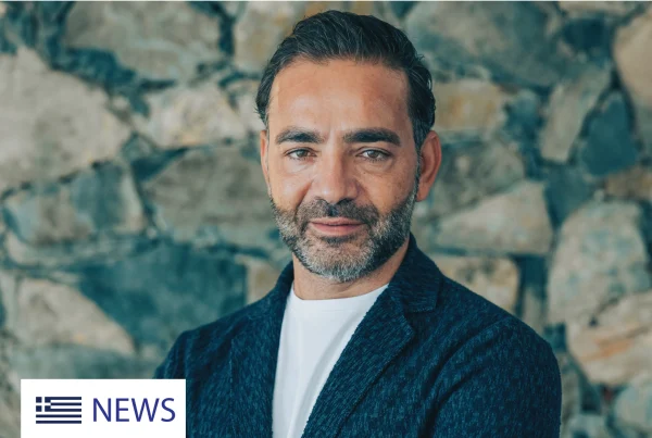 Yiannis Misirlis, Chairman at Imperio Group and LBDA, dressed in a dark blue jacket, standing in front of a stone wall