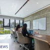 Modern meeting room with large windows and a long wooden table.