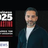 A promotional graphic featuring a man in casual attire with the text "IN Business 2025 Forecasting" and Greek text below. The design is in black and red tones.