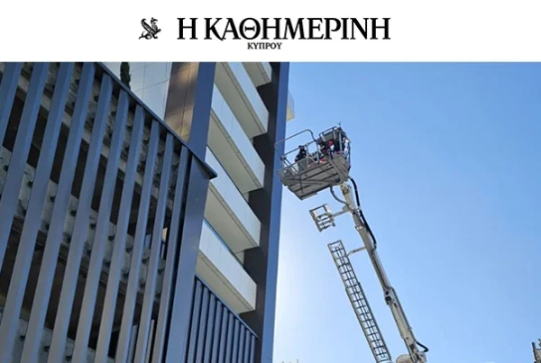 Firefighters conduct a high-rise rescue drill using an aerial platform outside a modern residential building.